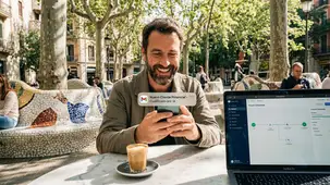 Dueño de negocio en Barcelona recibiendo una notificación de automatización de leads y captación de clientes cualificados por IA en su móvil